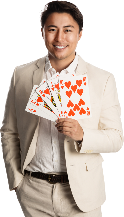 Smiling man in a light suit holding a fan of playing cards